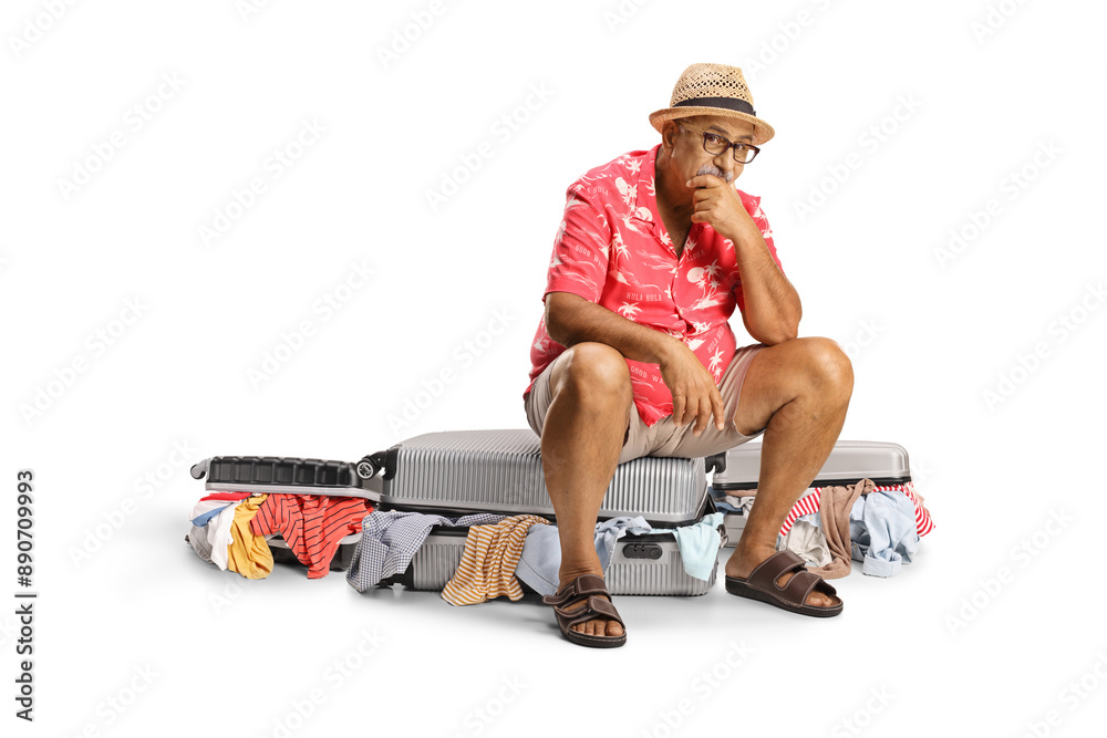 Sticker Sad mature male tourist sitting on a packed suitcase with messy clothes