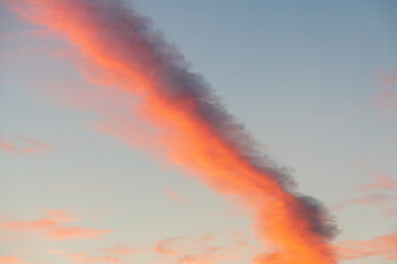 Orange contrail cloud at sunrise in the sky over Santa Monica, California