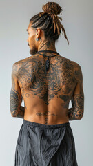 Fototapeta premium Tattooed man with intricate back and arm tattoos from behind