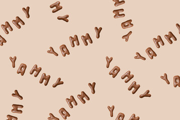 Sweet composition with the word Yammy on a beige background. Alphabet biscuits on a pastel background, top view