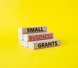 Small Business Grants symbol. Concept words Small Business Grants on wooden blocks. Beautiful yellow background. Business and Small Business Grants concept. Copy space