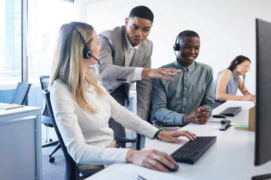 Call center, training and business people with discussion by computer for telecom, review or advice. Office, headset and mentor with help to trainee in customer service, telemarketing or CRM solution