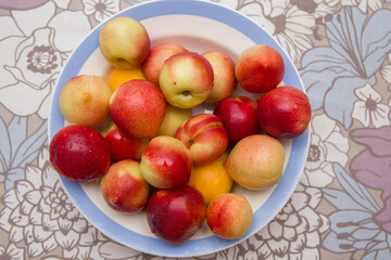 Ripe nectarines lie on a plate.