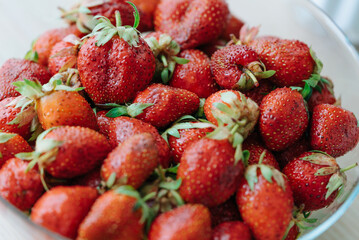Pile of fresh, ripe strawberries with vibrant red color and green stems, ready to eat. 