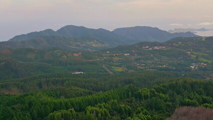 Panoramic aerial green mountains with scattered villages. Countryside landscape