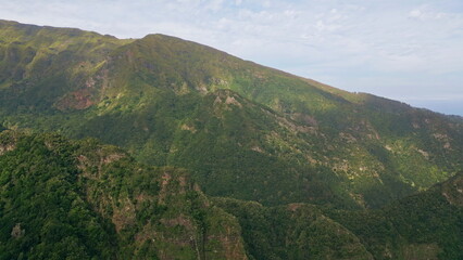 Vivid green mountains slopes and rugged hillsides aerial view. Scenic landscape