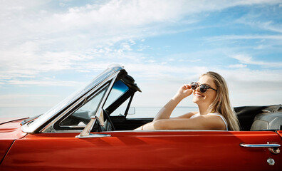 Happy woman, sunglasses and convertible by beach for road trip, adventure and freedom with holiday...