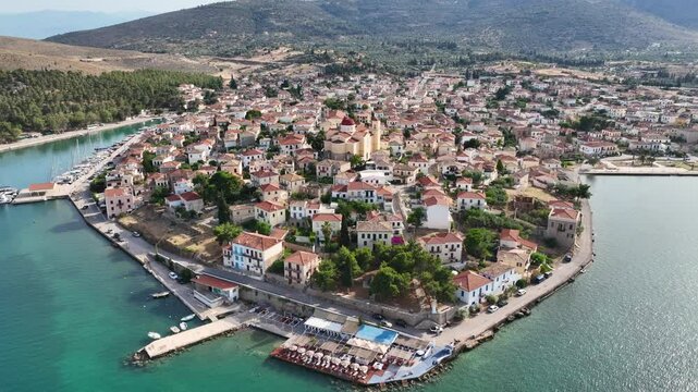 Aerial drone video from picturesque and traditional historic seaside village of Galaxidi featuring landmark church of Agios Nikolaos, Fokida, Greece