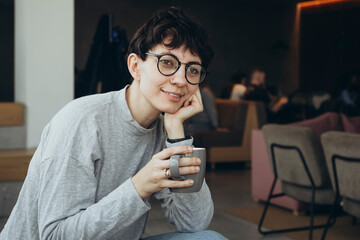 Sleepy young woman with a cup of coffee in the morning in the office.
