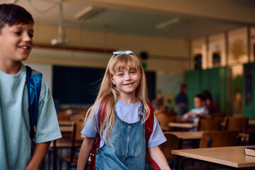 Happy schoolgirl in  classroom looking at camera.