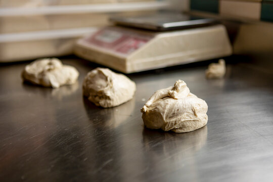 Fresh pizza dough on steel kitchen counter