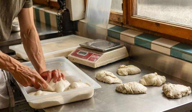 A chef preparing dough balls in a kitchen
