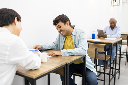 Adult students engaging in lively discussion at an English academy