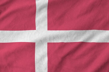 Denmark flag depicted on folded wavy fabric of old cloth close up