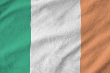 Ireland flag depicted on folded wavy fabric of old cloth close up