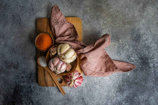 Rustic garlic and spices on cutting board in kitchen