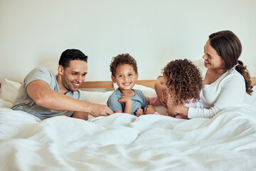 Happy, family home and bed with children and parents together with laugh, game and playing in the morning. Funny, smile and bonding with love, care and support with mom and dad in bedroom with kids