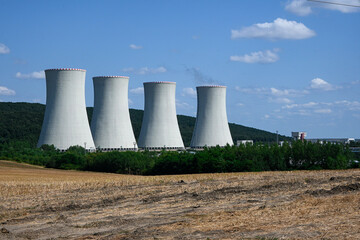 Four large nuclear power plant cooling towers releasing steam into the atmosphere