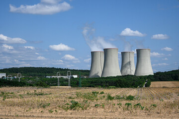 Four large nuclear power plant cooling towers releasing steam into the atmosphere