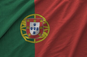 Portugal flag depicted on folded wavy fabric of old cloth close up