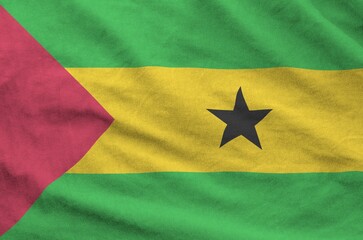 Sao Tome and Principe flag depicted on folded wavy fabric of old cloth close up