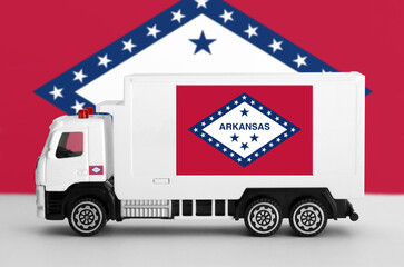 Arkansas US state flag depicted on side wall of white delivery van close up. Shipping and local delivery concept