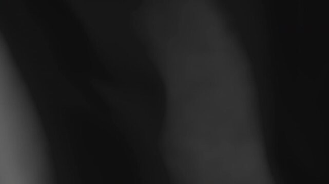 Black flag waving animated background. Plain or monochrome colored textile material moving with the wind footage. Template for a design or a sports team symbol.