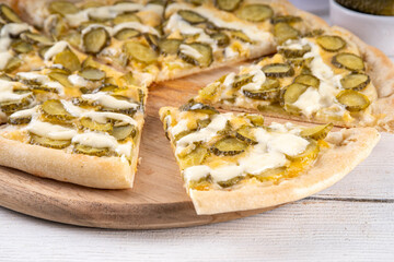 Pickle Pizza with cheese sauce and pickled cucumber