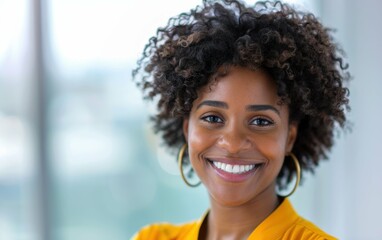 Fototapeta premium A Black woman with curly hair smiles brightly at the camera, wearing a yellow blouse