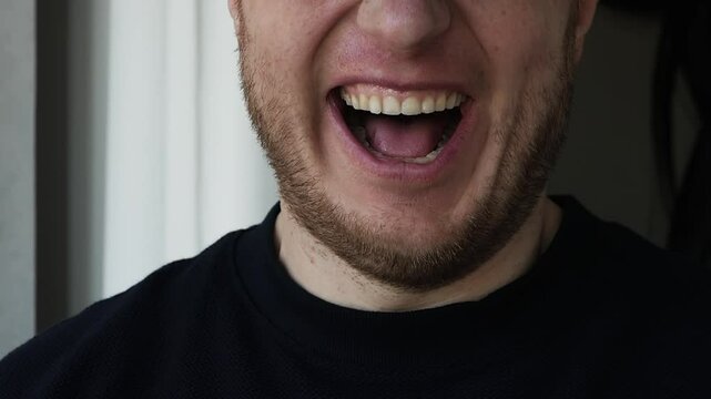 A man's sly smile. A man smiles deceptively, close-up of a man's strange smile