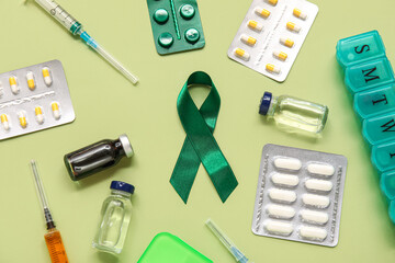 Satin green ribbon and medical supplies on color background, closeup. National cerebral palsy awareness month.