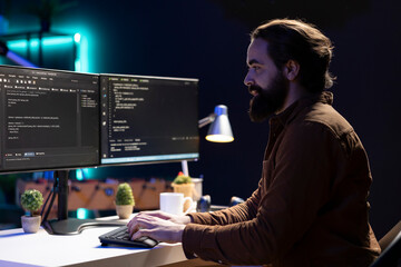 Freelancing computer engineer typing on keyboard, implementing security measures to protect company systems and data. Remote IT worker testing and debugging code for software applications