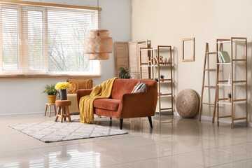Comfortable sofa with plaid and  beautiful daffodils in living room