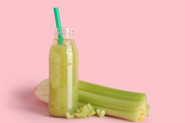 Bottle of fresh juice with celery on pink background