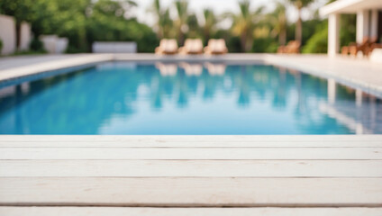 Empty white wooden table in front with blurred background of swimming pool