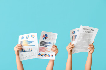 Female hands with financial graphics and documents on blue background