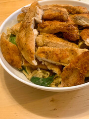 Roasted turkey in a bowl with linguine, spinach, and butter sauce