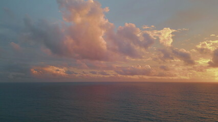 Cloudy sky golden sunset over tranquil ocean water aerial view. Serene evening