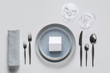 Beautiful table setting with blank invitation card on white background