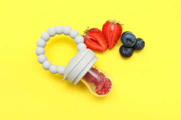 Baby nibbler with berries on yellow background