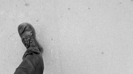 Man walks at a brisk pace POV. POV of a man in athletic pants and shoes walking down the road. Man's feet on the pavement, fast walking, fitness.