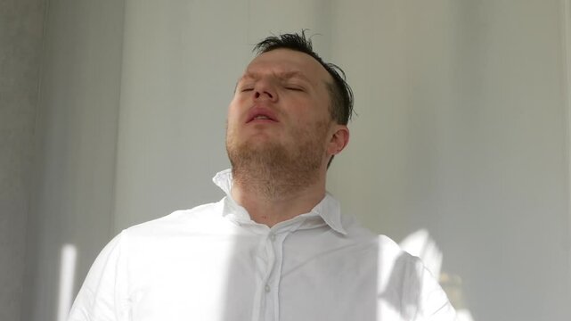 Morally tired elegant worker. Failure at work. A man is tired from office work. A man takes off his tie in a worker's office. People are hot in the summer.