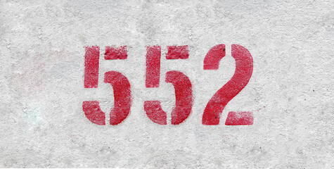 Red Number 552 on the white wall. Spray paint.