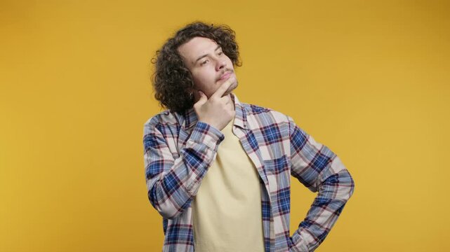 Curious thinking around curly man on yellow. Confused student guy finding answer