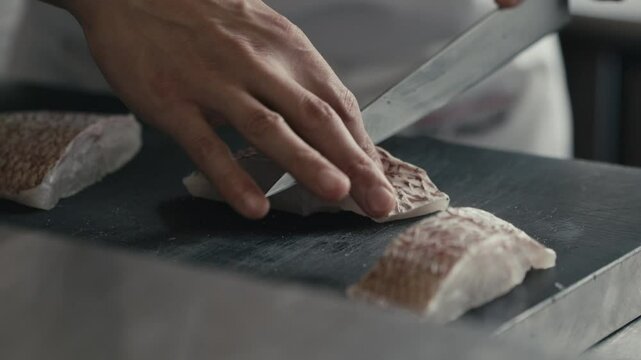 包丁で鯛・魚の切り身を捌く料理人の手元　料理・日本・和食・シェフ・シーフード