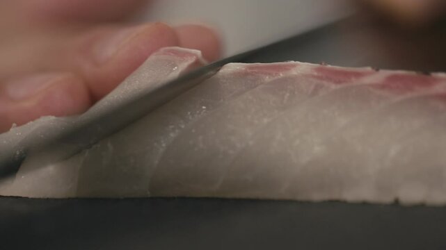包丁で捌き薄く切り,切り分けるシーフード魚　鯛の切り身　刺身・日本・和食・シェフ・料理・生魚・調理・料理人