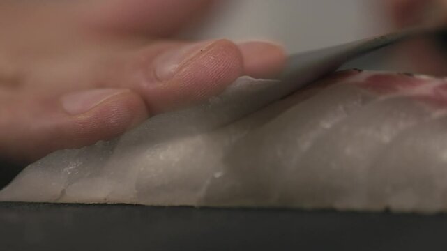 包丁で捌き薄く切り,切り分けるシーフード魚　鯛の切り身　刺身・日本・和食・シェフ・料理・生魚・調理・料理人