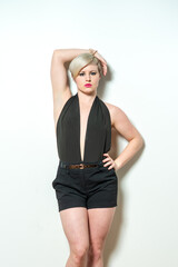 A woman in a black dress and black shorts is smiling and posing for a picture. Concept of confidence and happiness