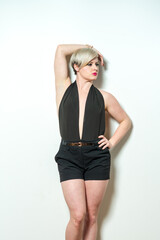 Naklejka premium A woman in a black dress and black shorts is smiling and posing for a picture. Concept of confidence and happiness