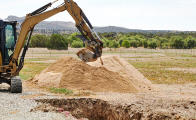 Steel Mini Bucket on the arm of an Excavator digging a trench